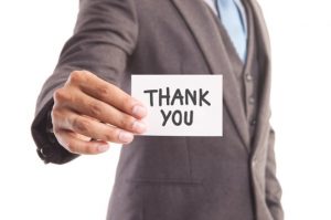 Businessman holding up a thank you note
