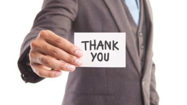 Businessman holding up a thank you note