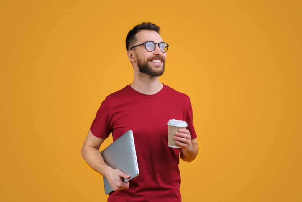 Excited business owner holding a laptop and coffee cup